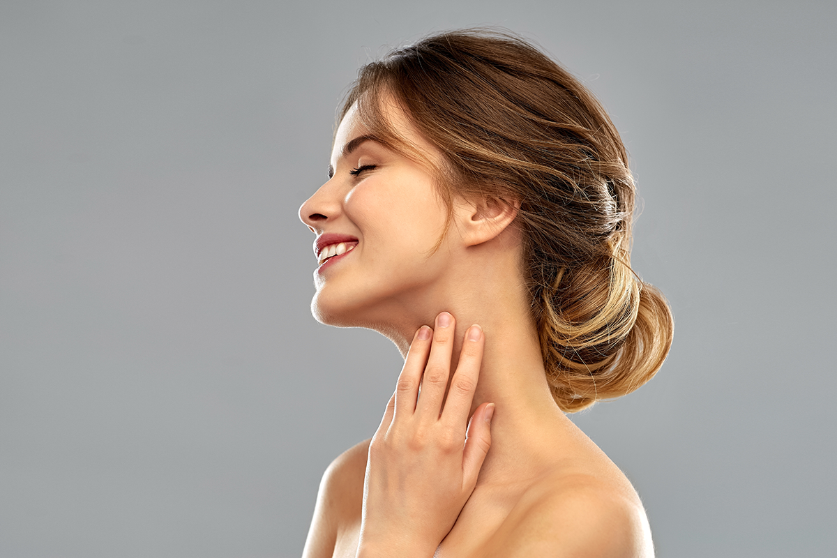 smiling young woman touching her neck
