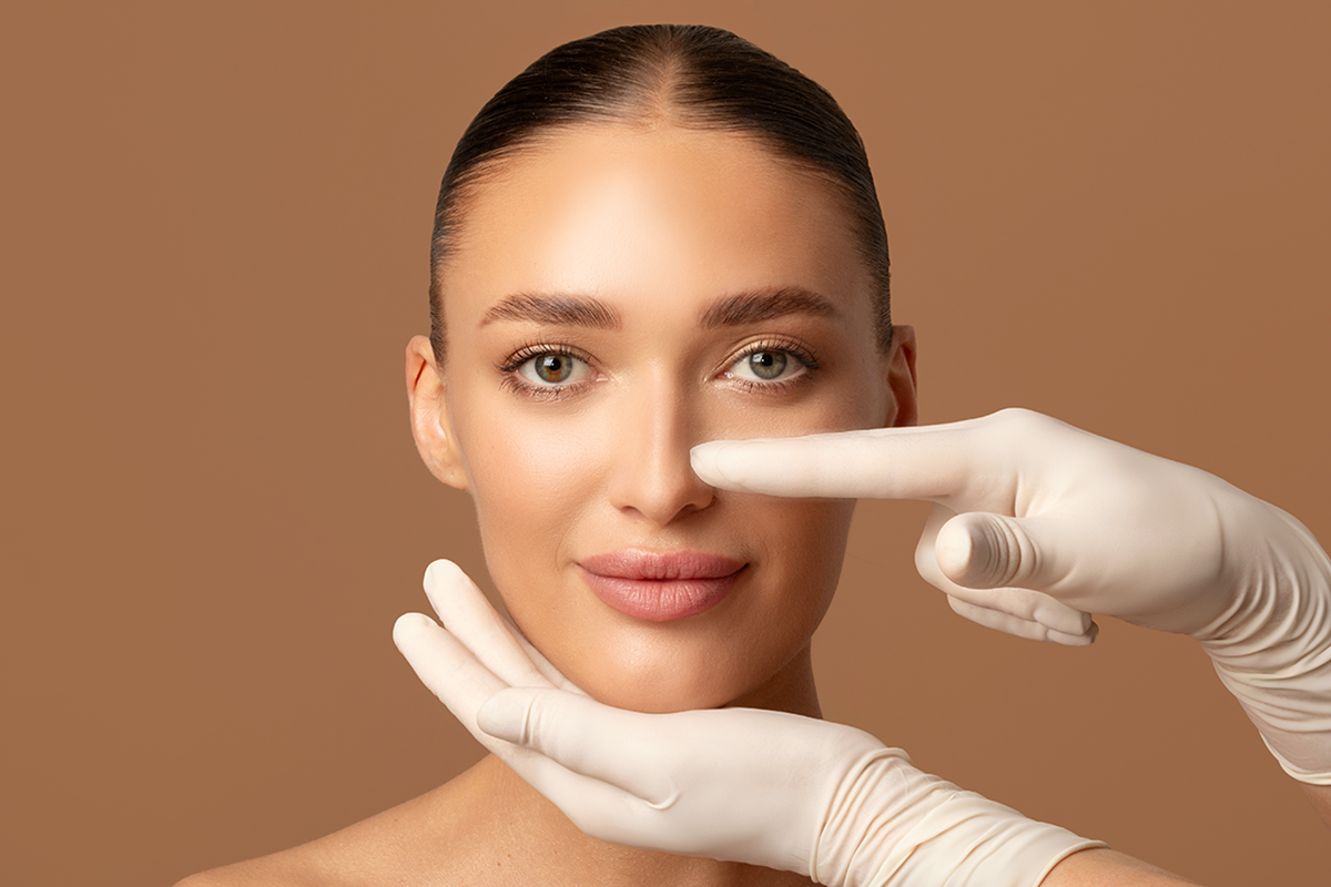 surgeon hands touching woman nose examining lady before plastic surgery