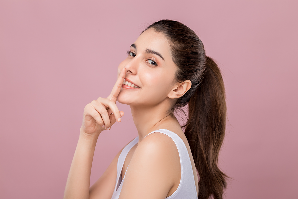 young beautiful caucasian woman with smiley face touching her nose