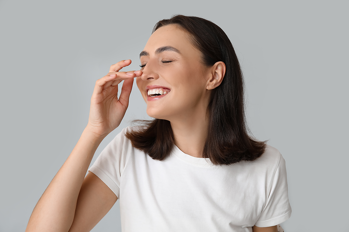 young woman touching her nose