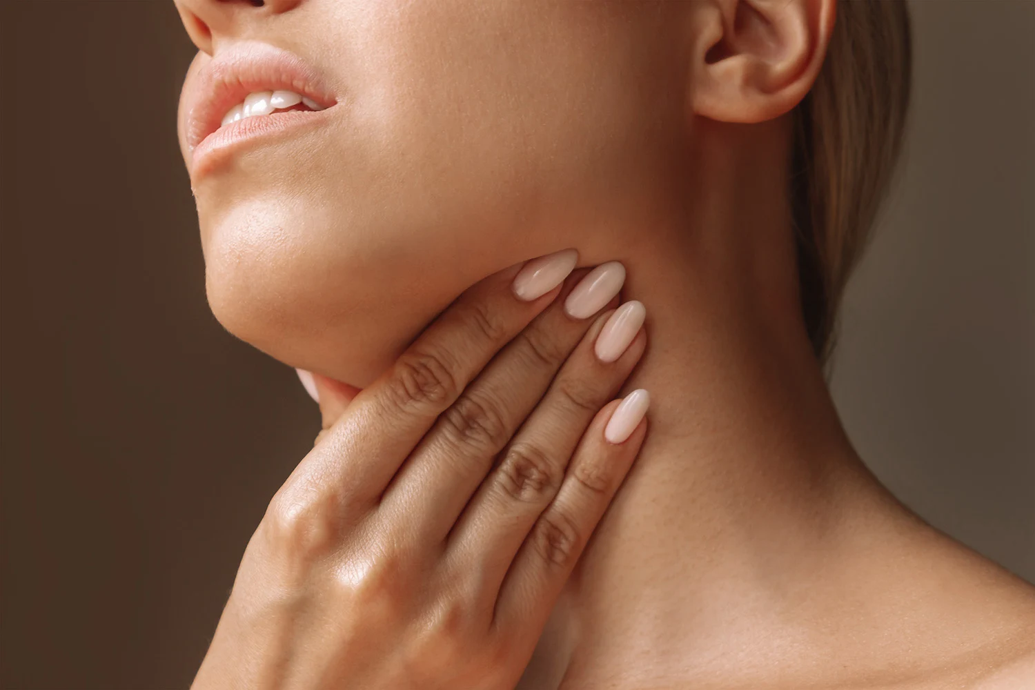 Close up of a person holding their hand against their neck Close up of a person holding their hand against their neck