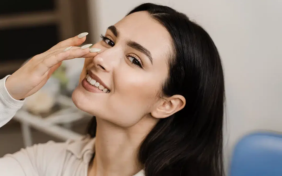 girl touching her nose and smiling